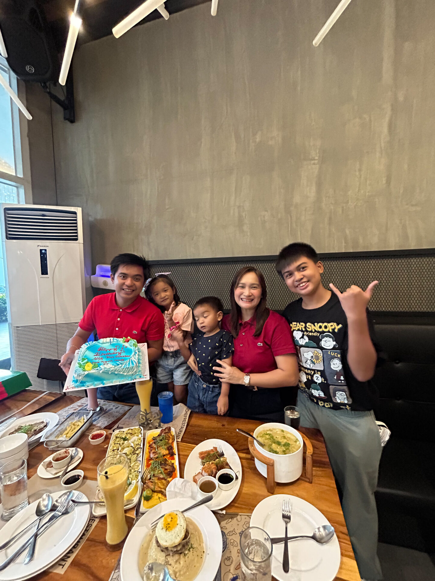 family taking picture of cake and foods.